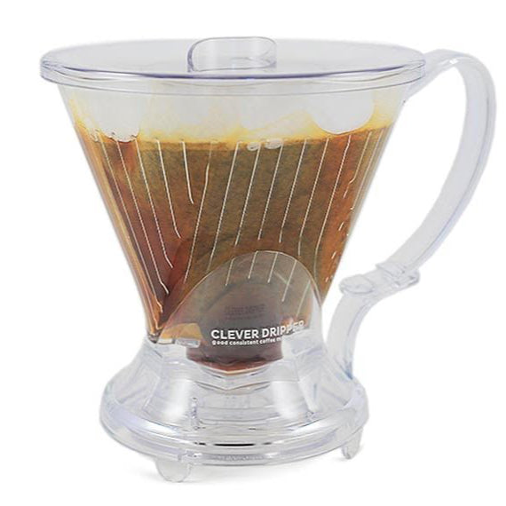 A clear plastic Clever Coffee Dripper with coffee grounds inside, sitting on a white background.