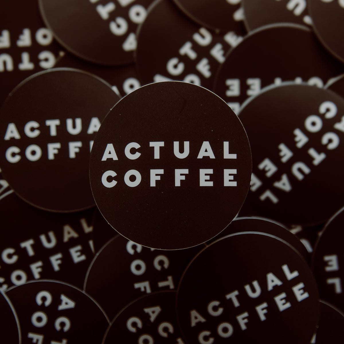 Stickers with 'Actual Coffee' text on a dark background