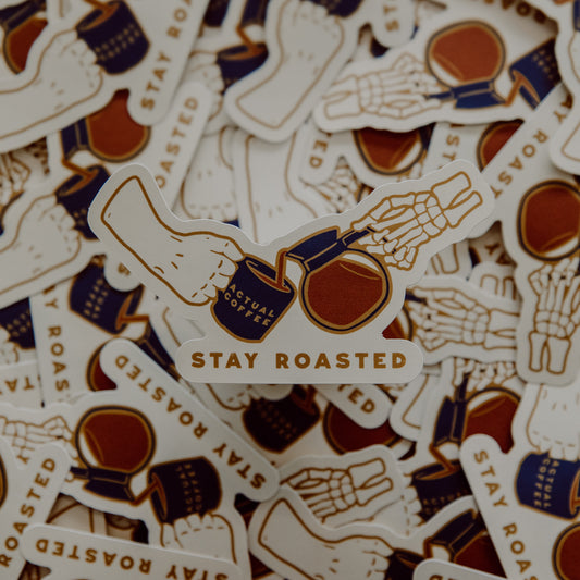 Stack of 'Stay Roasted' stickers with coffee-themed graphics.